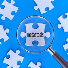 jigsaw puzzle with magnifying glass over the word &quot;metastasis&quot;&nbsp;