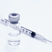 photograph of a syringe and vial of colorless liquid