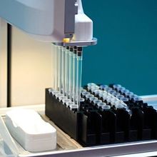 A semi-automated liquid handling robot with a multi-channel attachment for pipetting samples into an array format.