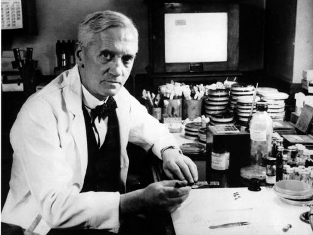 Alexander Fleming sitting at a desk