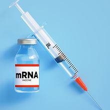 A vial labeled &ldquo;mRNA vaccine&rdquo; and a syringe on a blue background.
