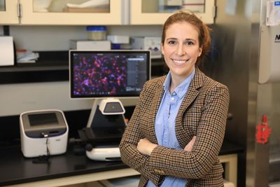 Kaitlyn Sadtler standing in front of a laboratory bench