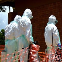 People in protective gear enter a building during an Ebola simulation exercise in Uganda in 2019. 